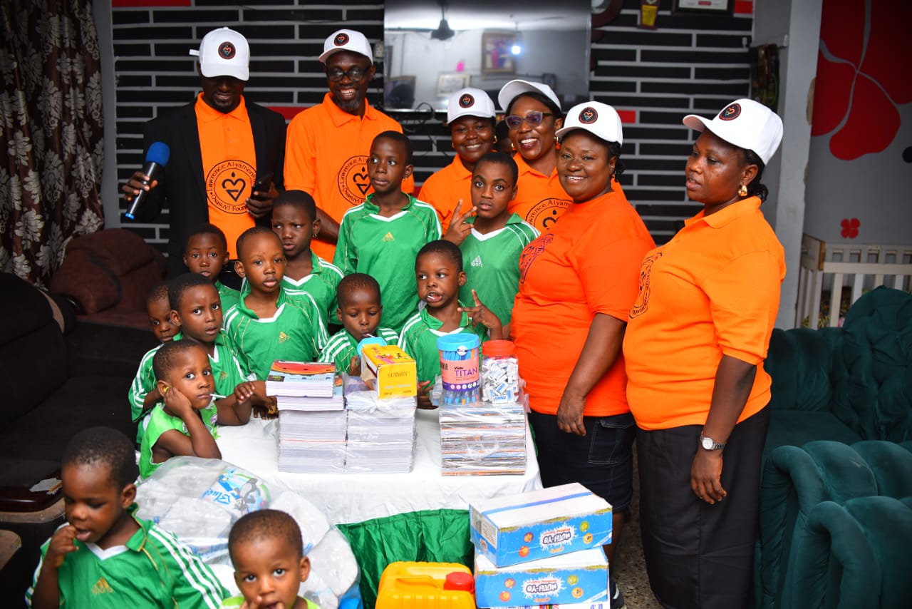 Children in green uniforms with LAOF volunteers and donated supplies